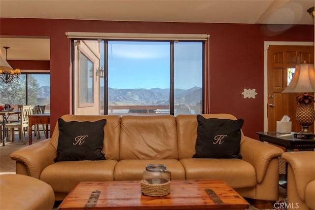 living room featuring plenty of natural light, a mountain view, and a chandelier