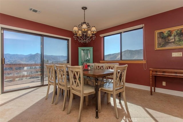 dining space with light tile patterned flooring, a chandelier, and a mountain view