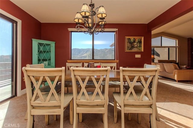 tiled dining room with an inviting chandelier and a mountain view