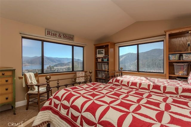 tiled bedroom featuring vaulted ceiling, a mountain view, and multiple windows