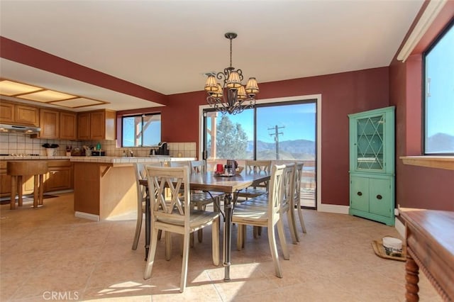 tiled dining room featuring a mountain view and a notable chandelier