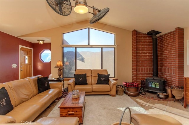 carpeted living room featuring vaulted ceiling, a mountain view, and a wood stove