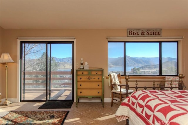 bedroom with access to exterior, tile patterned flooring, and a mountain view