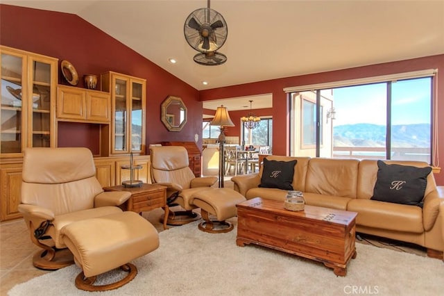 living room with lofted ceiling, light tile patterned floors, a notable chandelier, and a mountain view