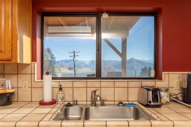 kitchen with a mountain view, tasteful backsplash, and sink