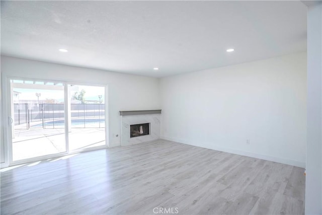 unfurnished living room featuring a fireplace and light hardwood / wood-style floors