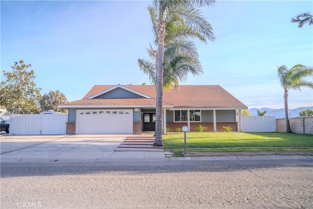 single story home featuring a garage, a front yard, and a mountain view