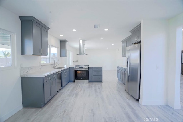 kitchen with sink, appliances with stainless steel finishes, gray cabinetry, and light hardwood / wood-style flooring