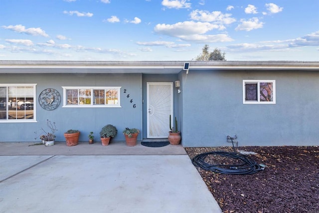 view of exterior entry with a patio area