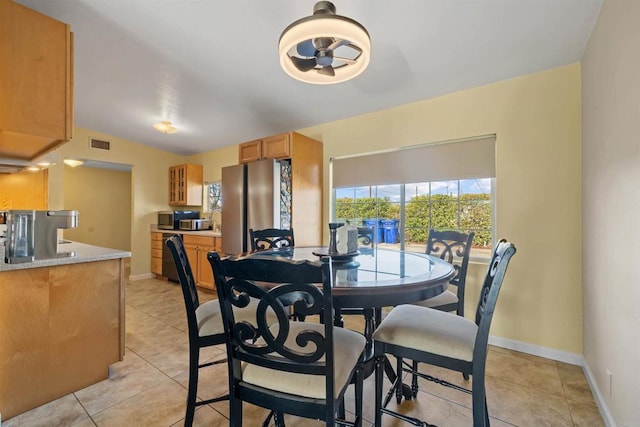 dining space featuring light tile patterned flooring and lofted ceiling