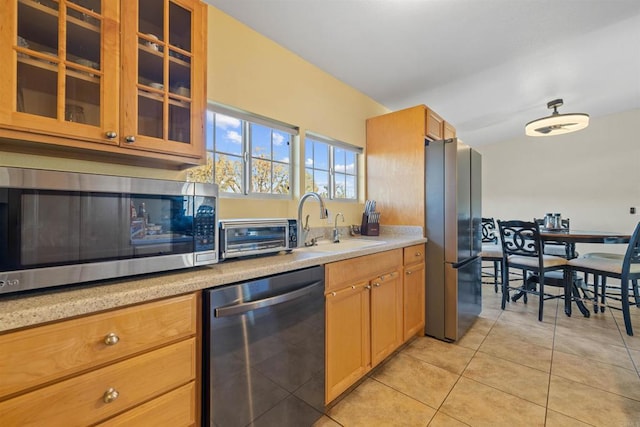 kitchen with stainless steel appliances, light tile patterned flooring, and sink