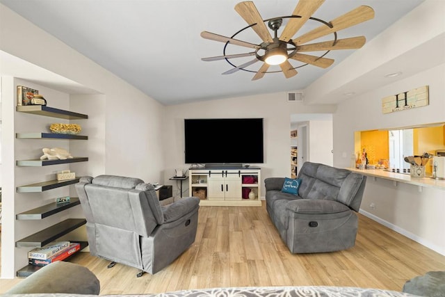 living room featuring lofted ceiling, built in shelves, ceiling fan, and light wood-type flooring