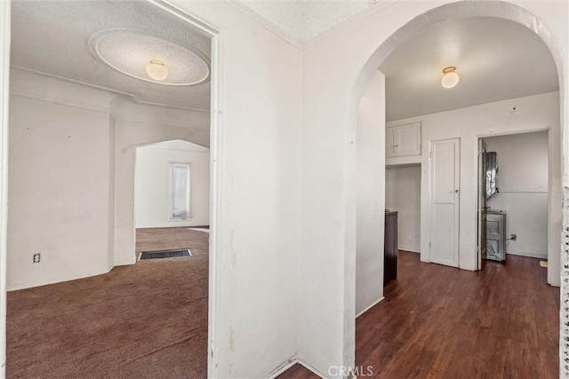 hallway featuring dark hardwood / wood-style flooring and a textured ceiling