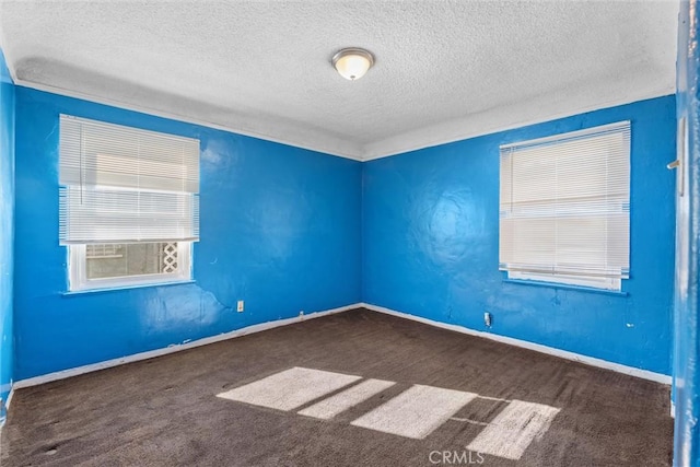 unfurnished room with dark carpet and a textured ceiling