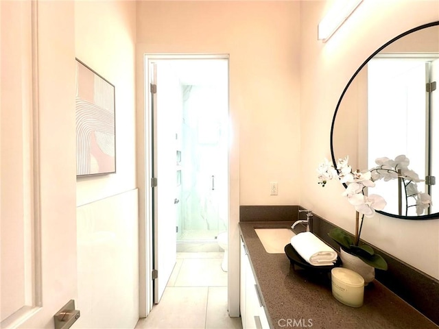 bathroom with a shower with shower door, tile patterned floors, vanity, and toilet