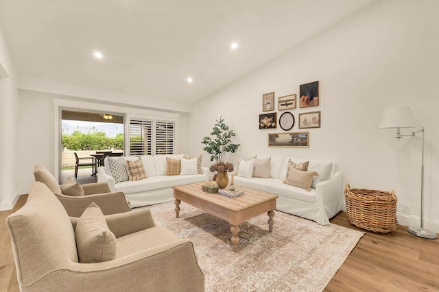 living room featuring vaulted ceiling and wood-type flooring