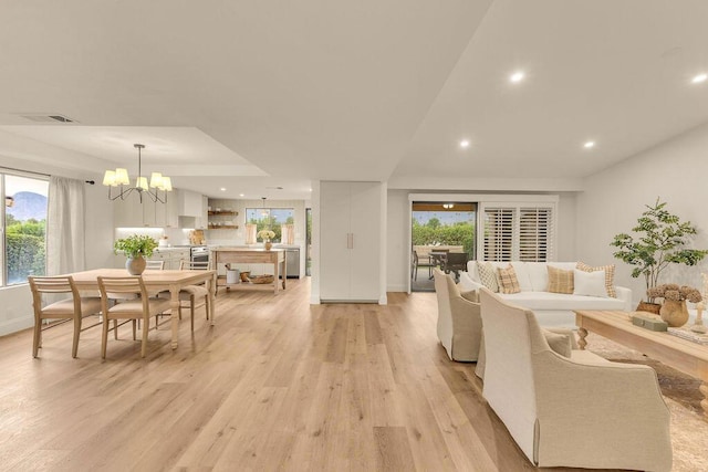 living room featuring light hardwood / wood-style floors and an inviting chandelier