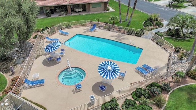 view of swimming pool with a community hot tub, a lawn, and a patio