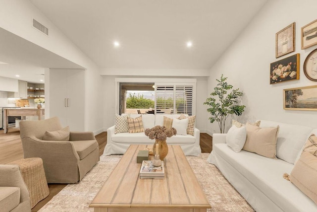 living room featuring light hardwood / wood-style flooring and vaulted ceiling