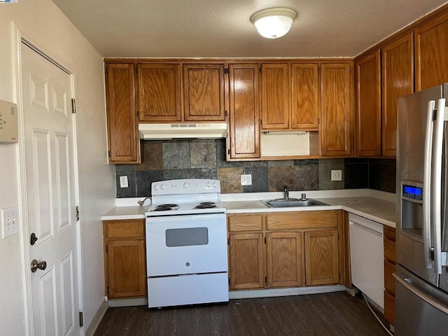 kitchen with tasteful backsplash, dark hardwood / wood-style floors, sink, and white appliances