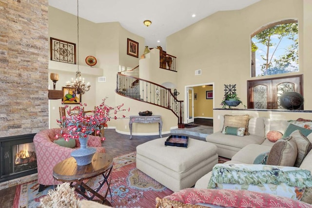 living room with an inviting chandelier, a fireplace, and a high ceiling