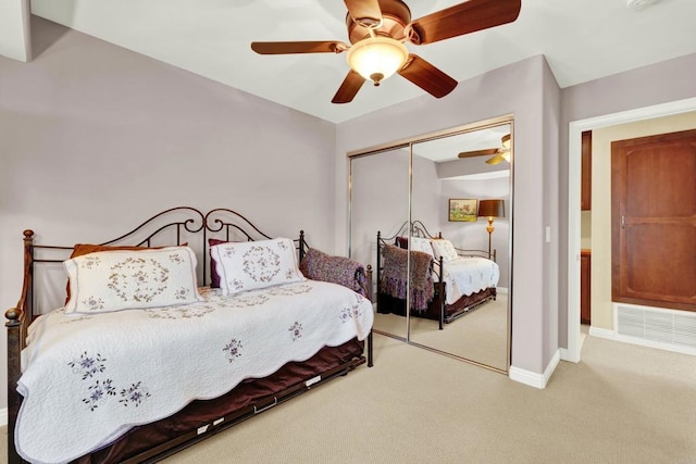 carpeted bedroom with ceiling fan and a closet