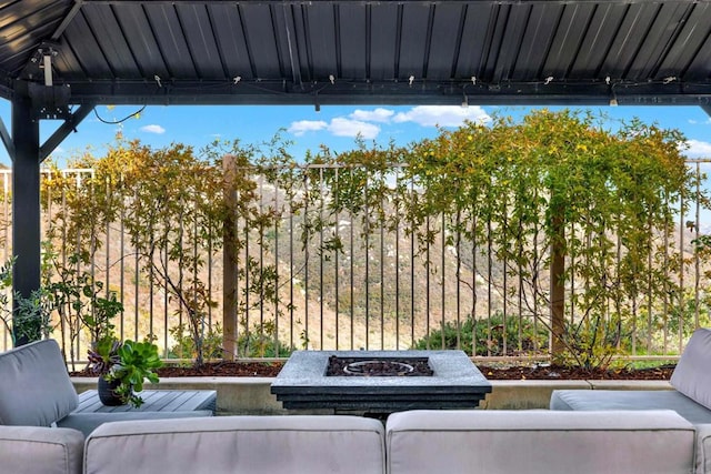 view of patio with an outdoor living space with a fire pit