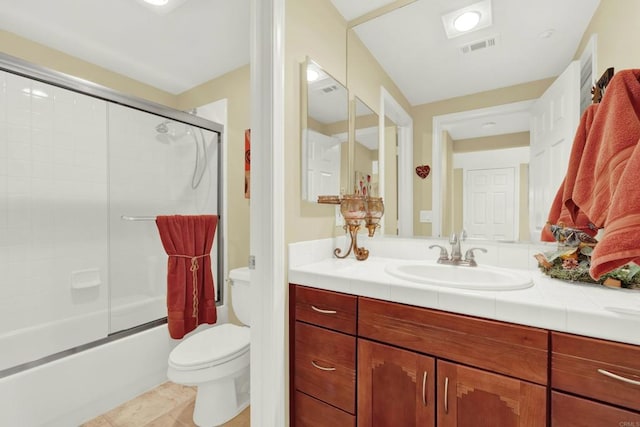 full bathroom with shower / bath combination with glass door, tile patterned floors, vanity, and toilet