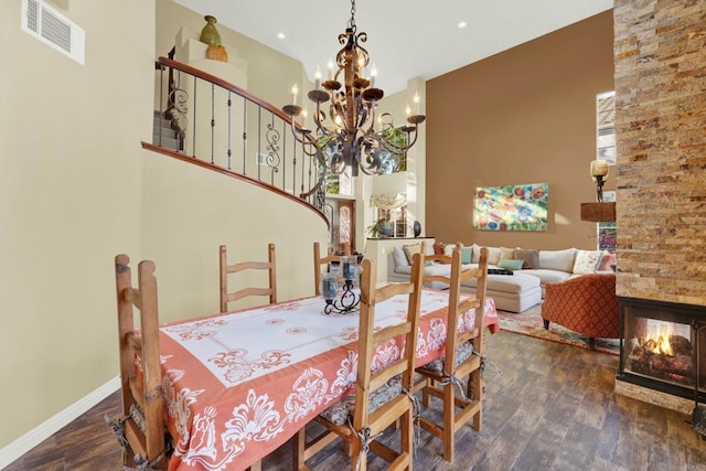 dining room with a notable chandelier, dark wood-type flooring, and a high ceiling