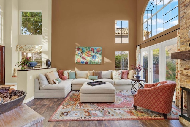 living room featuring dark wood-type flooring, plenty of natural light, and a high ceiling