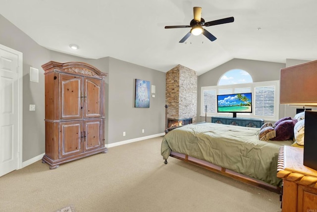 carpeted bedroom with a stone fireplace, vaulted ceiling, and ceiling fan