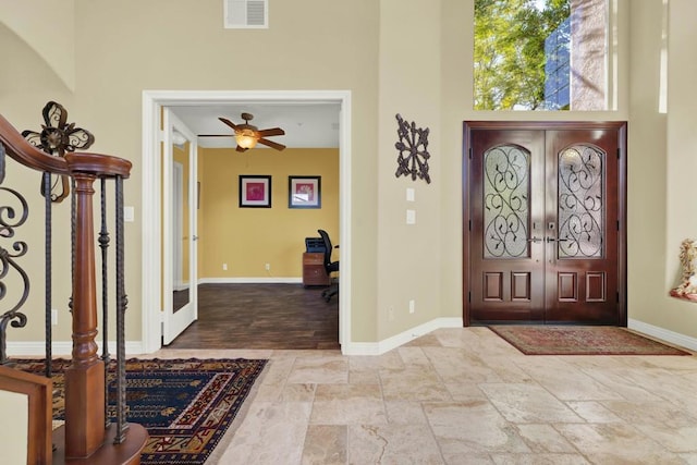 foyer featuring a towering ceiling and french doors