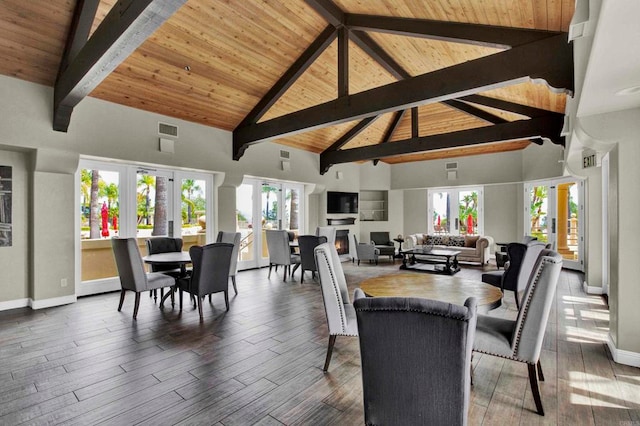 dining space with beam ceiling, hardwood / wood-style flooring, high vaulted ceiling, and french doors