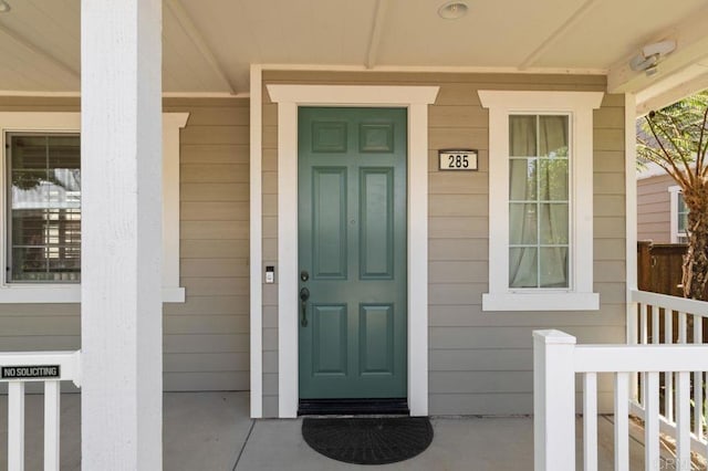 view of exterior entry featuring covered porch