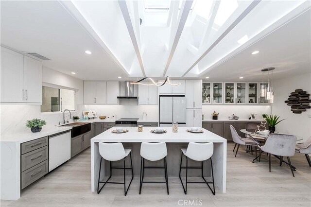 kitchen with gray cabinets, dishwasher, hanging light fixtures, a kitchen island, and white fridge