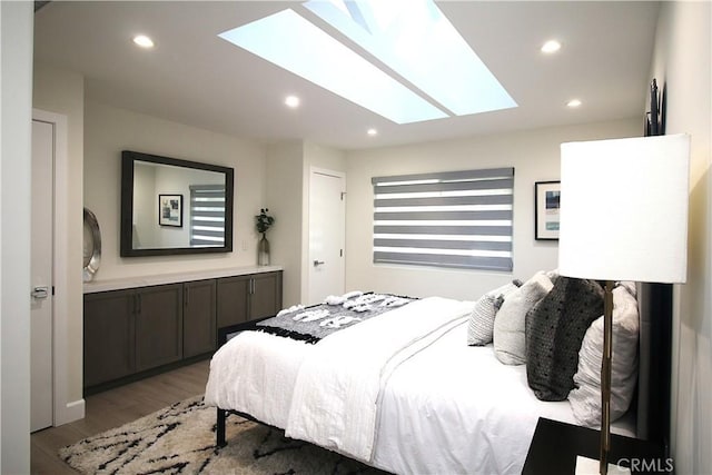 bedroom featuring a skylight and hardwood / wood-style floors