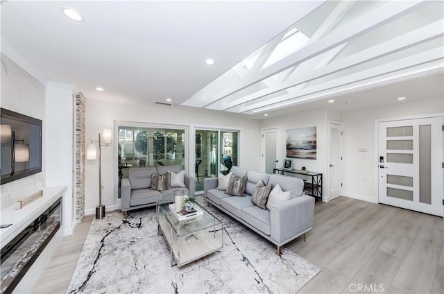 living room featuring a high end fireplace and light hardwood / wood-style floors