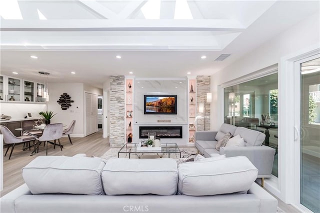 living room with beamed ceiling and light wood-type flooring