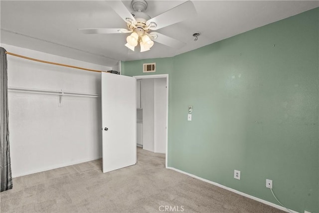 unfurnished bedroom with ceiling fan, a closet, and light carpet