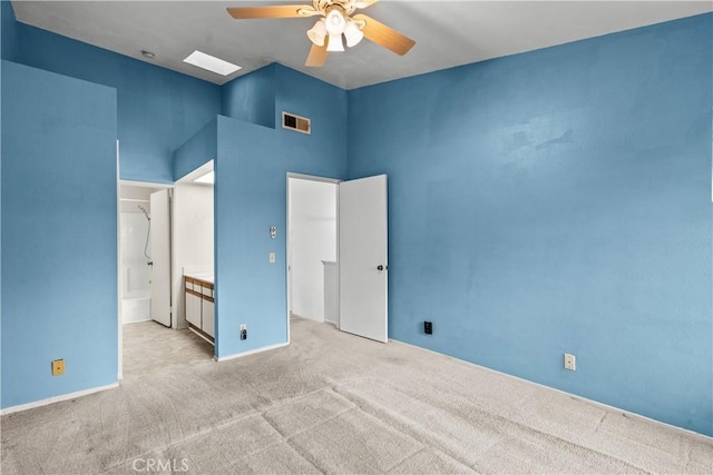 unfurnished bedroom with ceiling fan, light colored carpet, and connected bathroom