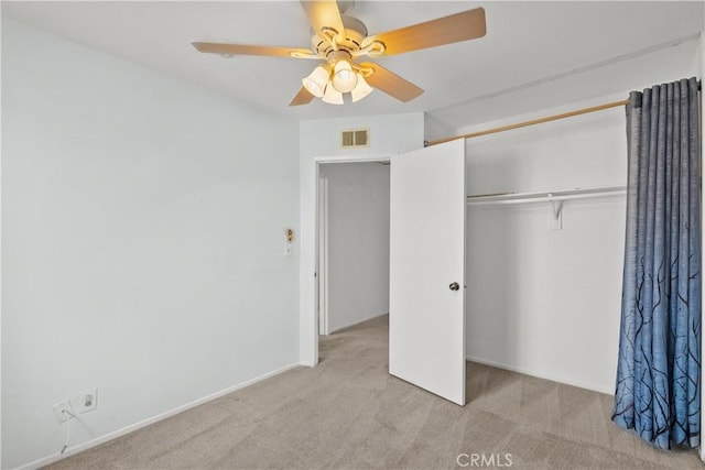 unfurnished bedroom with ceiling fan, light colored carpet, and a closet