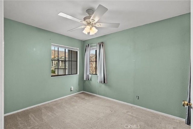 carpeted spare room with ceiling fan