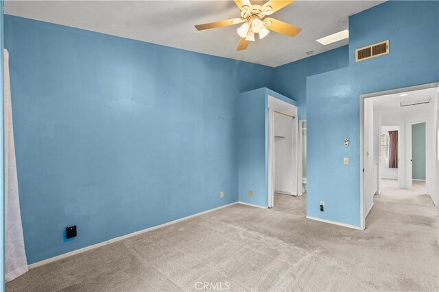 unfurnished bedroom with ceiling fan, light colored carpet, and a closet