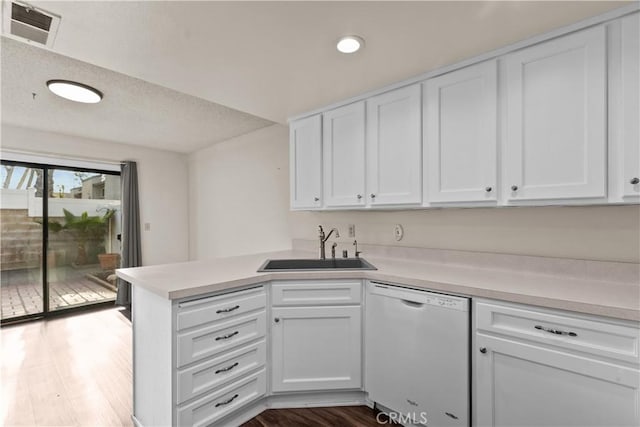 kitchen with white cabinets, dishwasher, sink, dark hardwood / wood-style floors, and kitchen peninsula