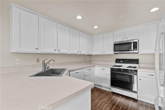 kitchen featuring white cabinetry, sink, white appliances, and dark wood-type flooring