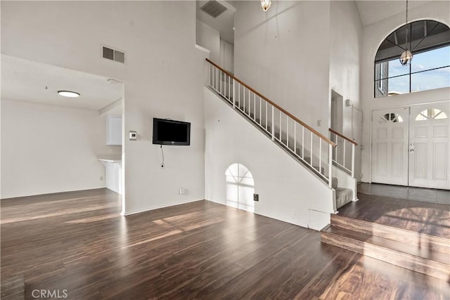 foyer with dark wood-type flooring, a high ceiling, and an inviting chandelier