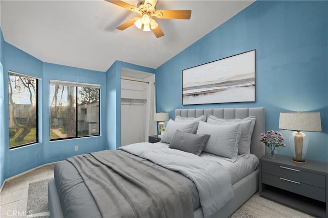 bedroom with ceiling fan, a walk in closet, a closet, and lofted ceiling