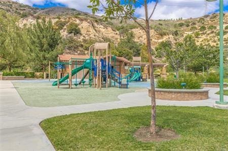 view of play area featuring a mountain view and a lawn