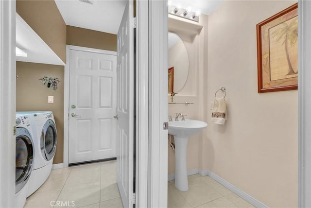 laundry area featuring light tile patterned floors, sink, and washer and dryer