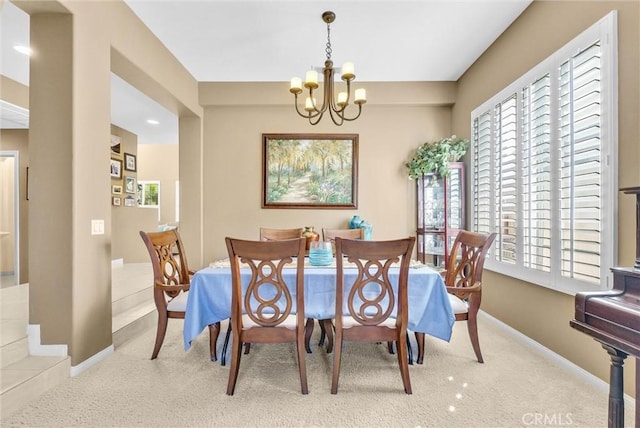 dining room featuring a chandelier and light colored carpet